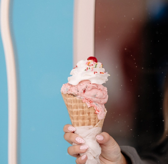 Ice Cream cone with whip cream and a cherry